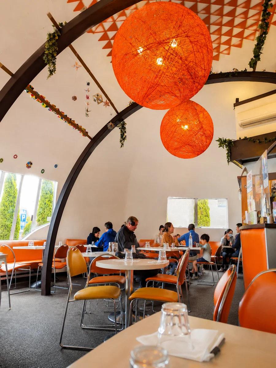 The curved dining room and orange pendant lights at Cameron Japanese Family Restaurant